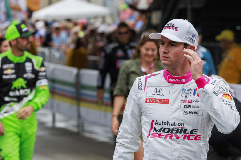Race car driver Kyle Kirkwood walks onto the track during